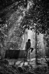 Man sitting on stool at forest