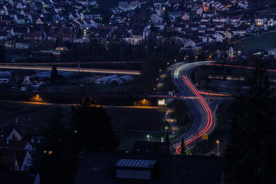 Road with light trails in blue hour with cityscape