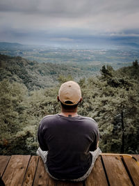 Rear view of man looking at mountain against sky