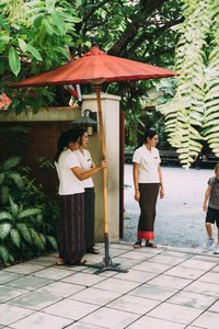 People standing on footpath by plants