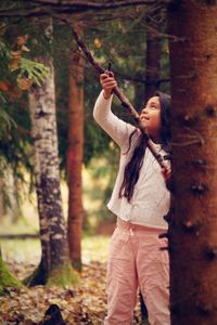 Girl looking up while holding stick