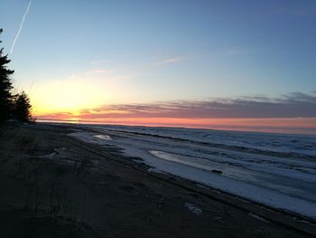 Scenic view of beach against sky during sunset