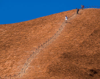 People on desert against clear sky