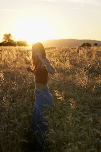 Rear view of woman standing on field