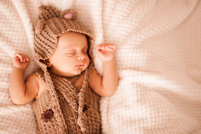 Cute baby boy sleeping on duvet in bedroom