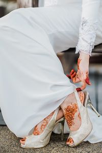 Low section of woman standing on white umbrella