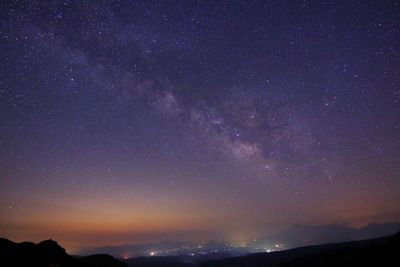 Low angle view of silhouette mountain against sky at night