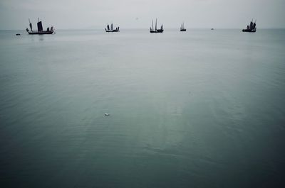 Boats sailing on sea against sky