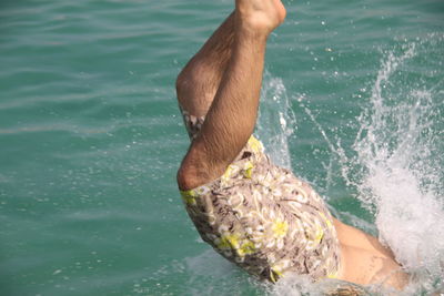 Low section of person swimming in water