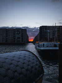 River by buildings in city against sky