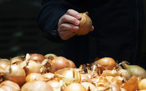 Male hand holds onion over counter