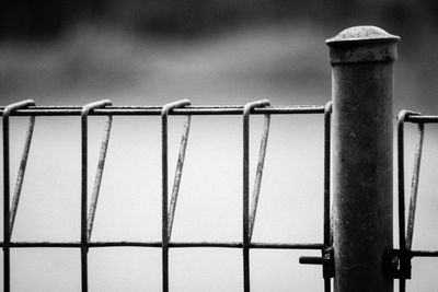 Close-up of metal fence against sky