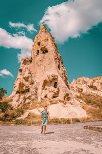 Woman standing on rock against sky