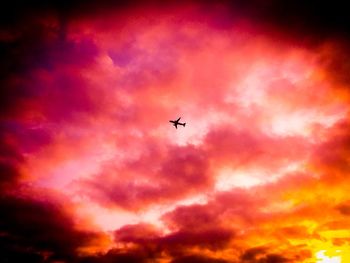 Low angle view of silhouette airplane flying in sky