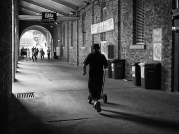 Rear view of man walking in corridor of building