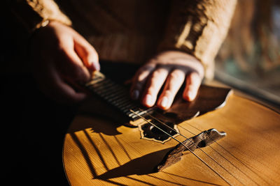 Domra folk musical instrument. female hands with 4 strings natural wood handmade musical instrument