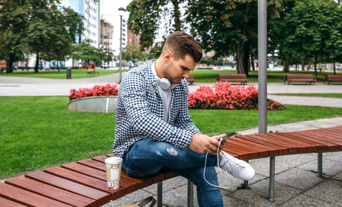 Young man sitting on bench in park