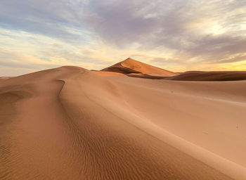 Scenic view of desert against sky during sunset