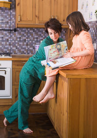 Young woman reading book at home