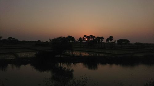 Scenic view of lake against sky at sunset