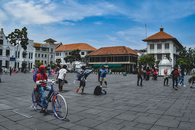 People on street against buildings in city