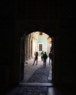 Rear view of people walking on building