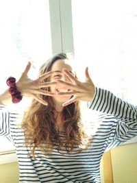 Smiling young woman gesturing at home