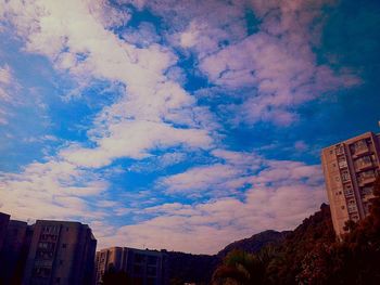 Low angle view of buildings against cloudy sky