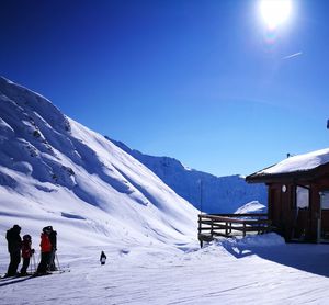 People on snowcapped mountain against clear blue sky