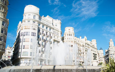 Low angle view of buildings in town against sky