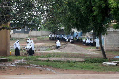 Group of people on cemetery against trees