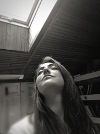 Close-up of young woman with eyes closed standing indoors