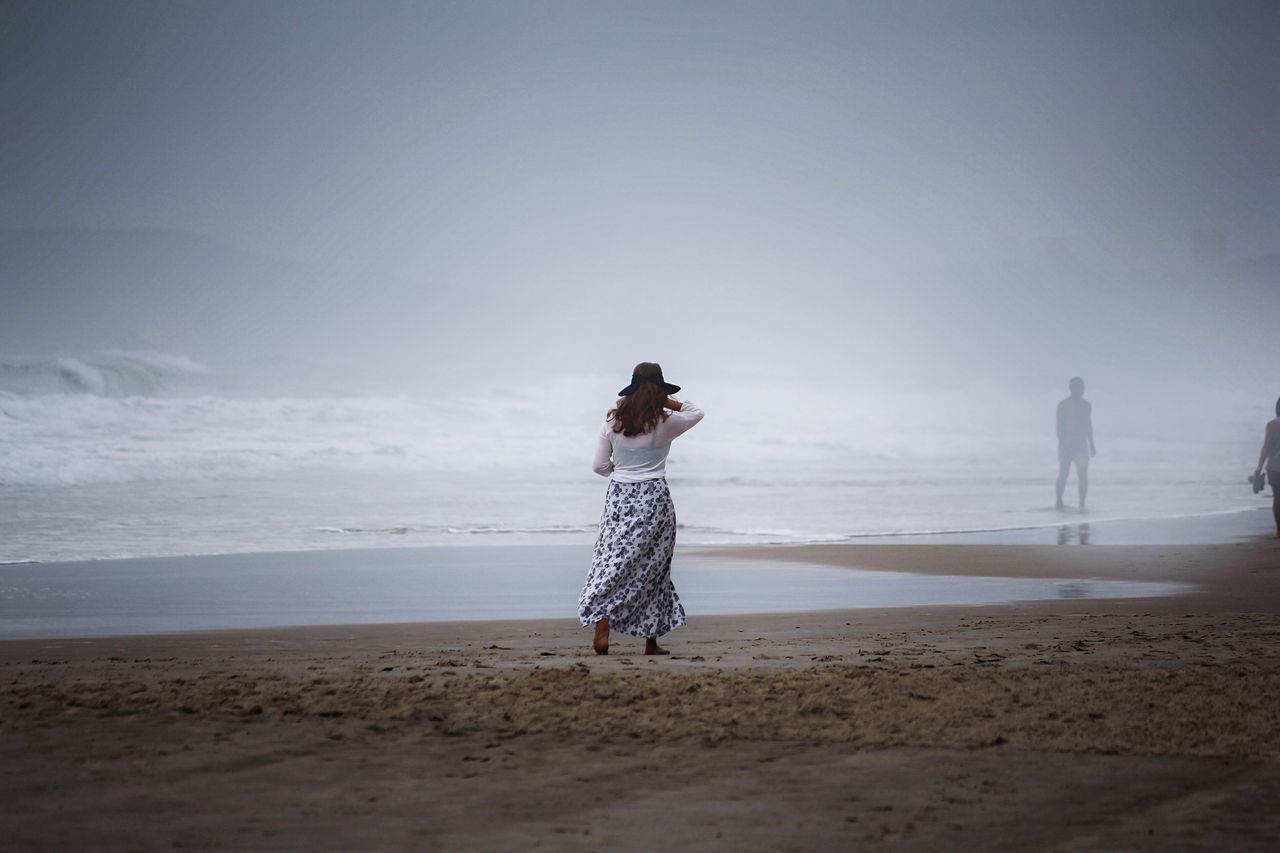 sea, beach, horizon over water, full length, shore, water, lifestyles, leisure activity, rear view, sand, sky, standing, tranquil scene, tranquility, scenics, beauty in nature, casual clothing, vacations