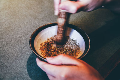Cropped image of hand grinding spices in mortar and pestle