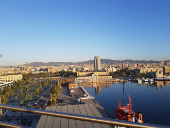 High angle view of buildings by river against clear blue sky