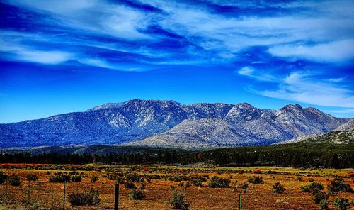 Scenic view of mountains against blue sky