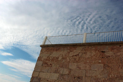 Low angle view of building against cloudy sky