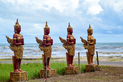 Rows of kinnara statues or mythical creatures in buddhism against the blue sea and sky