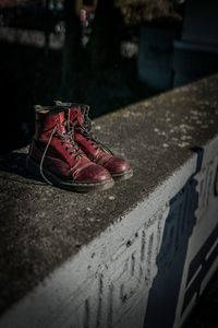 Close-up of shoes on retaining wall