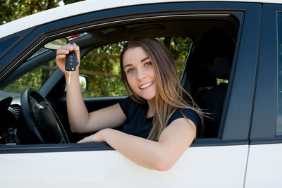 Portrait of smiling woman sitting in car