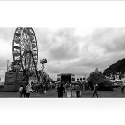 Amusement park ride against cloudy sky