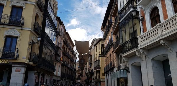 Low angle view of buildings in town against sky