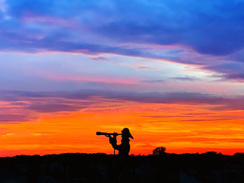 Silhouette man playing against sky during sunset