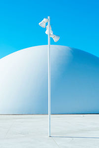 Low angle view of wind turbine against clear blue sky