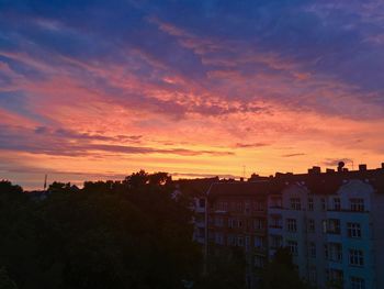 Houses against sky at sunset