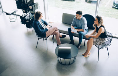 Businessman discussing with colleagues at desk in office