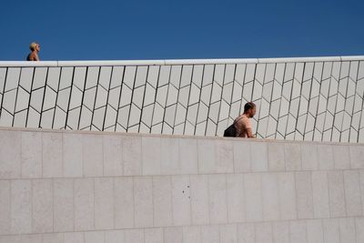 Full length of shirtless man in water against clear sky