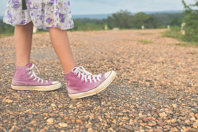 Low section of girl walking in summer