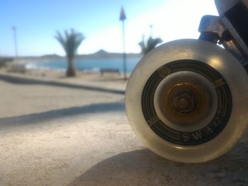 Close-up of camera on beach against sky