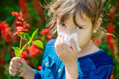 Portrait of young woman blowing flowers